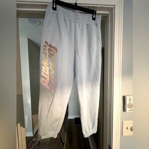 Fabletics baby blue jogging pants with colorful saying down one leg. Size L